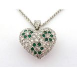 An 18 carat white gold, diamond and emerald heart pendant by J & Co, pave set overall with