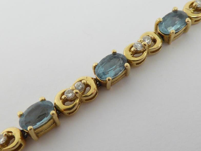 An aquamarine and diamond line bracelet, composed of alternate oval cut aquamarines and pairs of - Image 2 of 2
