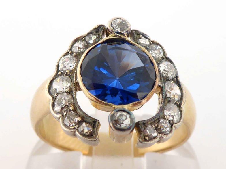 An early 20th century synthetic sapphire and diamond ring, the central round cut sapphire 8 x 4.5mm,