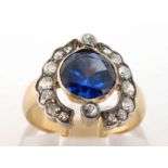 An early 20th century synthetic sapphire and diamond ring, the central round cut sapphire 8 x 4.5mm,