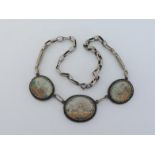 A necklace composed of three Indian miniature paintings, each in oval unmarked silver frame,probably