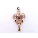 An Edwardian garnet, peridot and seed pearl pendant, the central round cut garnet 4.8mm, within a