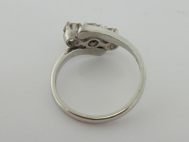 A three stone diamond ring, obliquely set with three tapering old cut brilliants totalling approx. - Image 2 of 4