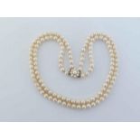 A two strand cultured pearl necklace, composed of uniform 6.5mm pearls, to a 9 carat gold box snap