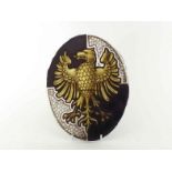 An 18th. century or earlier armorial stained glass oval panel of an eagle displayed, gold, with