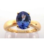 An 18 carat gold and tanzanite ring, the central oval cut stone approx. 2 carats, the shank fully