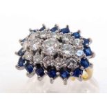 An 18 carat gold, diamond and sapphire dress ring, composed of a central rectangular cluster of