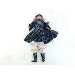 A Victorian wax headed doll in highland dress with blonde hair, blue ceramic eyes, black velvet