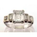 A five stone diamond ring, the central emerald cut approx. 1.35 carats, claw set above baguette