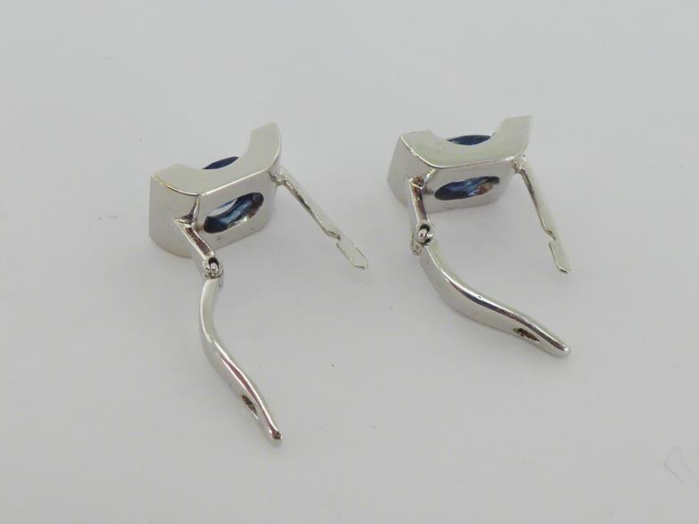 A sapphire and diamond pendant and earring suite, the pendant with a central oval cut stone, in a - Image 4 of 4