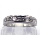 A diamond half hoop ring, channel set with ten small princess cuts totalling approx. 0.57 carat, the