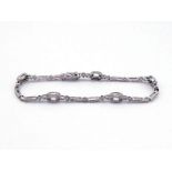 An 18 carat white gold and diamond line bracelet by Luke Stockley, in the Art Deco manner, pave