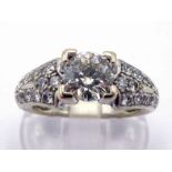 A diamond dress ring, the central brilliant approx. 1 carat, box claw set above pave set