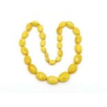 A butterscotch (osseous) amber necklace, composed of graduated oval beads, 50cm long, 24.6gms