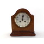 A mahogany cased eight day mantel clock with shaped domed top, boxwood stringing and inlay,