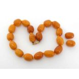 A butterscotch amber necklace, composed of oval bead, to a gold barrel clasp, 49.4gms CONDITION: