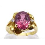An 18 carat gold, rubellite tourmaline and diamond ring, the central oval cut tourmaline 10.3 x 7.