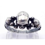 A silver skull ring, finely modelled as a partial skull with cherub shoulders, finger size R/S, 6.
