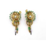 A pair of 1950s emerald and diamond ear clips, centred on a cluster of small brilliants, to a