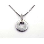 An 18 carat white gold and diamond pendant, the plain, polished disc pendant 15mm diameter, below