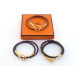 HERMES, three leather and gilt metal jumbo hook bracelet/chokers, 37cm long, each signed to the