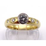 An 18 carat gold and diamond ring, the central brilliant approx. 0.28 carat, collet set above two