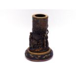 A Japanese stained ivory vase together with carved lacquered wood stand, the vase carved in high