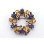 An Italian 18 carat gold and sapphire circlet brooch, composed of an openwork wreath of scrolling