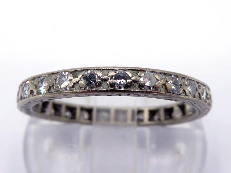 A 14 carat white gold and diamond eternity ring, composed of pave set single cuts, the band import