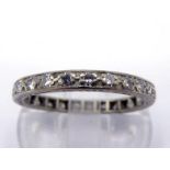 A 14 carat white gold and diamond eternity ring, composed of pave set single cuts, the band import