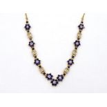 A sapphire and diamond necklace, composed of alternate daisy clusters of sapphires and pave set