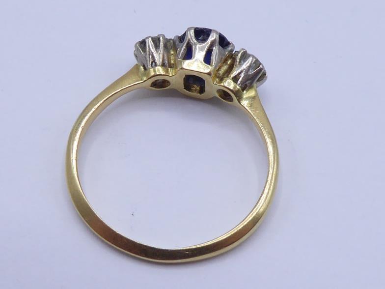 A sapphire and diamond three stone ring, the central oval cut stone 6 x 5mm, claw set between two - Image 2 of 3