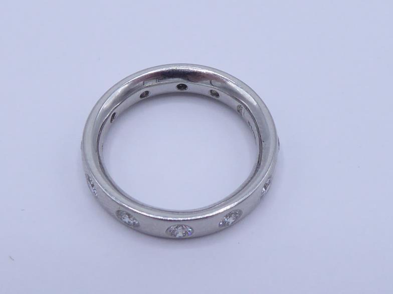 A platinum and diamond eternity band by Garrard & Co, the band rub over set at intervals with twelve - Image 2 of 3