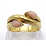 VAN CLEEF & ARPELS, A French 18 carat gold and coral ring, the pear shaped peau d'ange cabochons rub