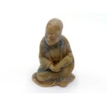 A Chinese carved soapstone figure of seated Luohan, with hands holding a scroll, engraved and
