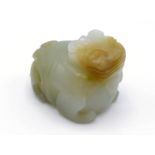 A Chinese carved pale celadon jade pendant, in the form of a recumbent kylin, detailed carving of