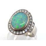 A precious opal and diamond cluster ring, the central oval opal cabochon 12 x 9.5mm, in a surround