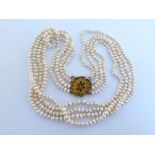 A four strand freshwater pearl necklace, composed of uniform off-round pearls, the four strands of