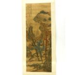A Chinese painted silk scroll depicting scholars in a mountainous landscape, poems in the top left
