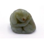 A Chinese carved celadon jade table ornament, modelled as a monkey squatting in front of a big peach