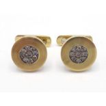 A pair of diamond cufflinks, the circular brushed gold links set to the centre with a cluster of