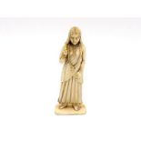 A carved ivory standing figure of a woman (possible Indian) with long flowing hair, one hand