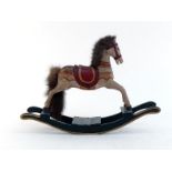 A carved and painted wooden toy rocking horse with fur mane and tail on long curved rockers. In very