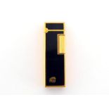 Colibri, a gilt metal and black lacquer lighter, in box CONDITION: scratches to lacquer