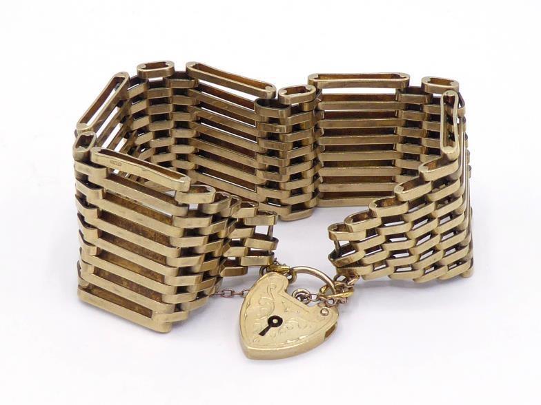 A 9 carat gold gate link bracelet, each link eight bars deep, to a heart shaped padlock clasp, fully