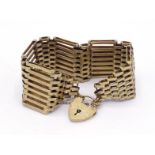 A 9 carat gold gate link bracelet, each link eight bars deep, to a heart shaped padlock clasp, fully