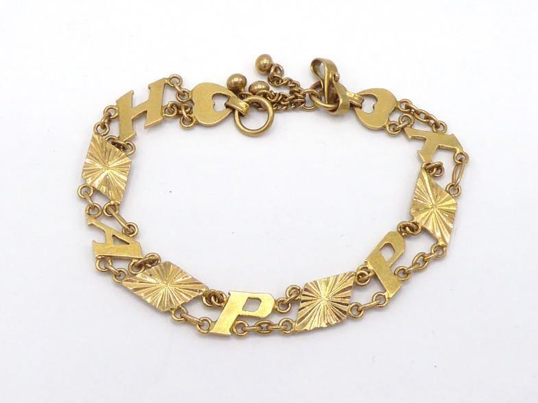 A yellow metal (tests 14 carat gold) bracelet, the links spelling out 'HAPPY', to a hook clasp, 17cm