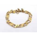 A yellow metal (tests 14 carat gold) bracelet, the links spelling out 'HAPPY', to a hook clasp, 17cm