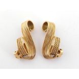 A pair of 1950s yellow metal (tests 14 carat gold) ear clips, of scroll design, 3,5cm long, 17.