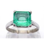 An emerald ring, the emerald cut approx. 1.77 carat, claw set above a white metal shank (tests 18
